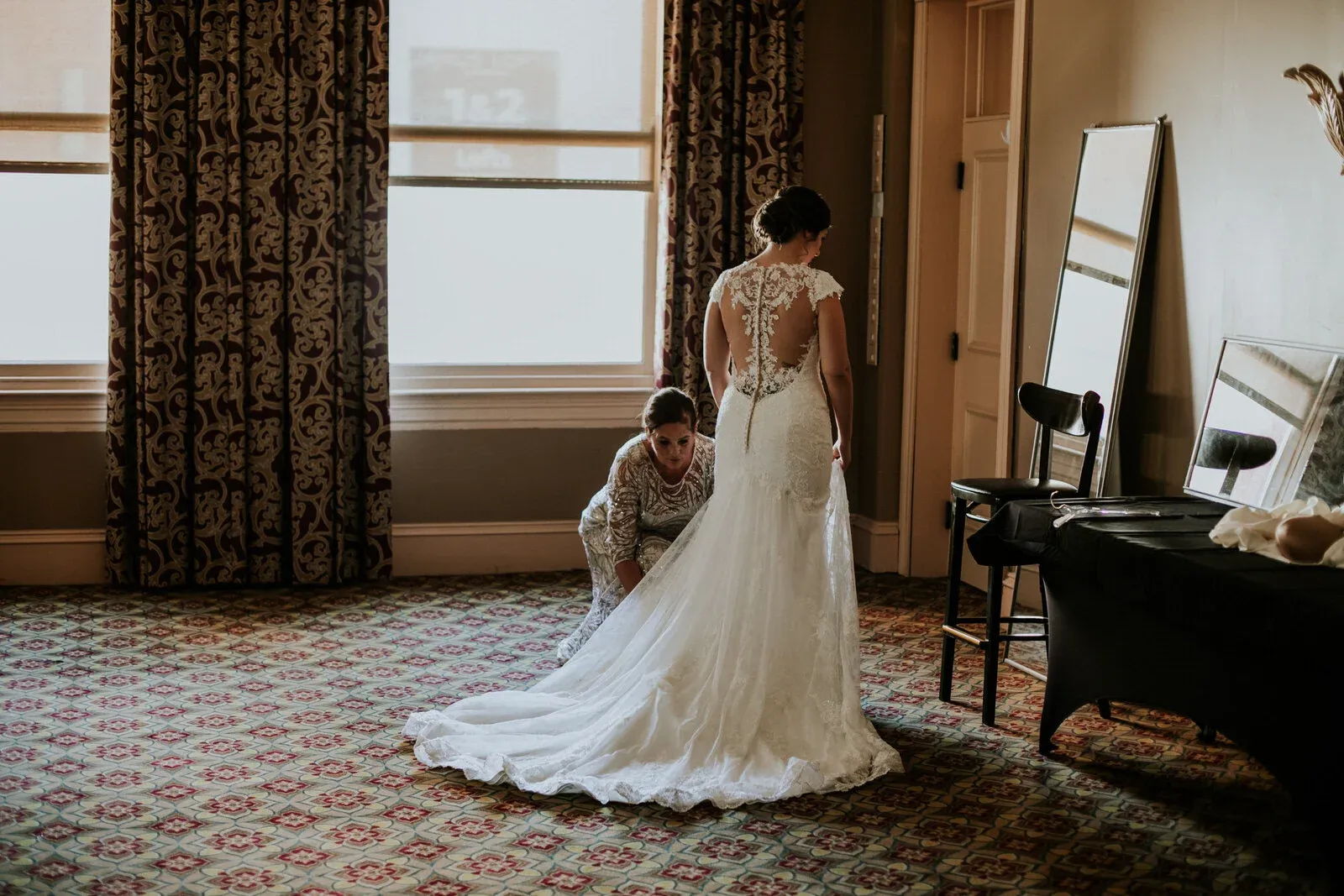 The bride was helped into her dress by just her mother in a very large room. This was shot on a 50 mm from a ways away.