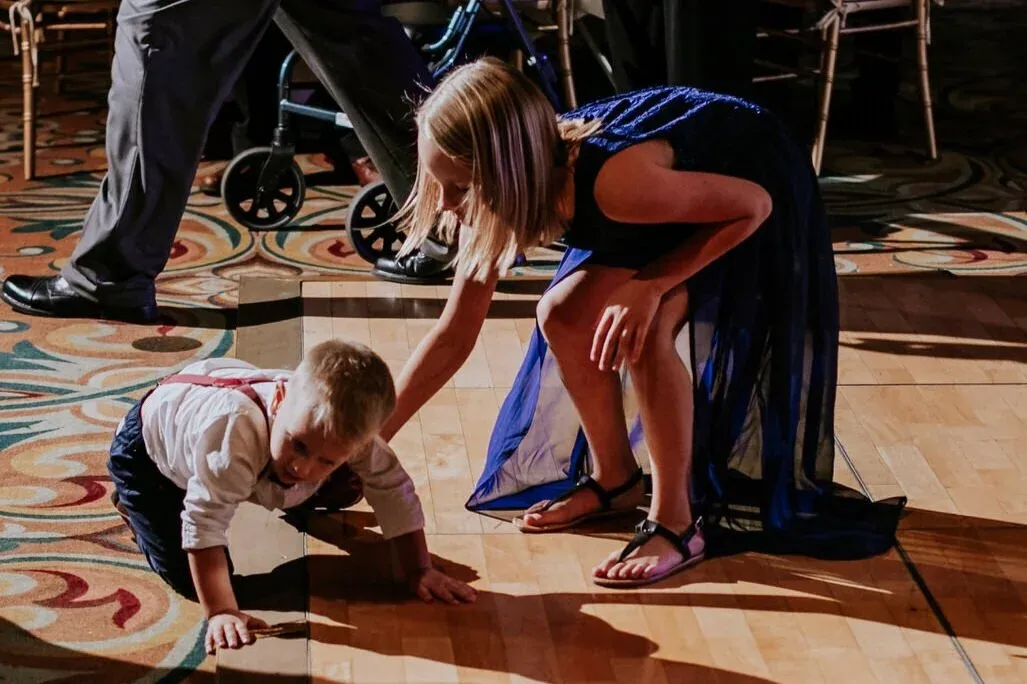 This was shot with a 50 mm from a ways away, and then cropped in to focus on just the girl helping her brother off the floor during open dancing.