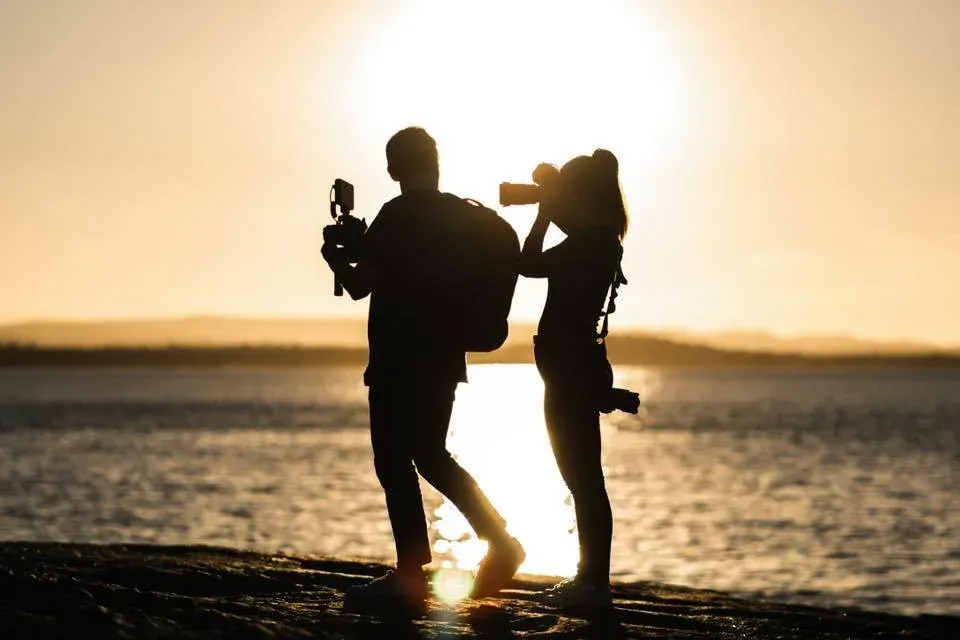 Silhouette of videographer and photographer at sunset